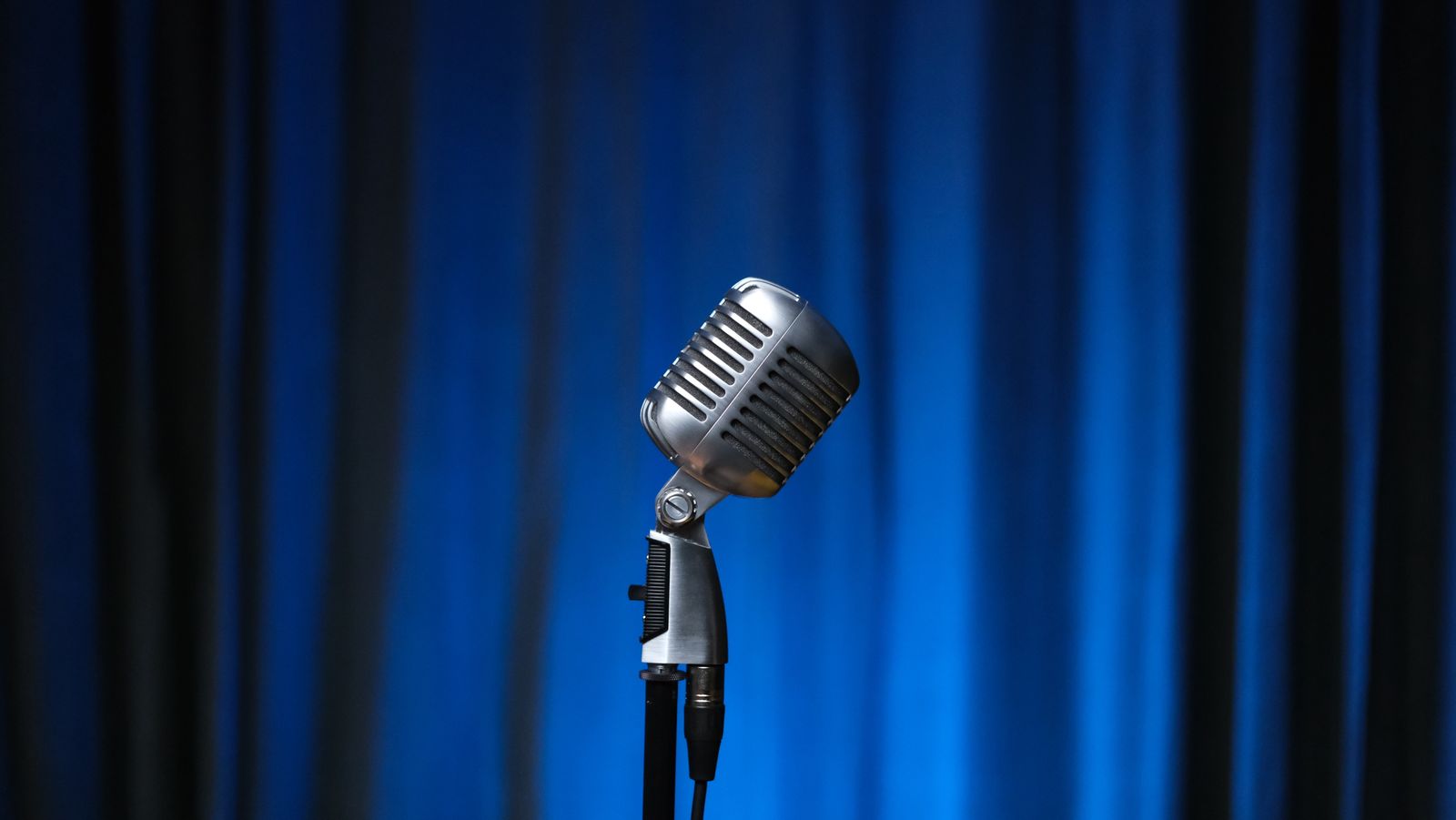 A podcast host adjusting a microphone before recording an episode of The Echo Hour